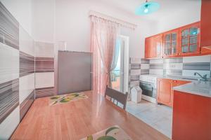 a kitchen with orange cabinets and a table with a chair at Mirror Beach Ksamil - Vila Zervo in Sarandë