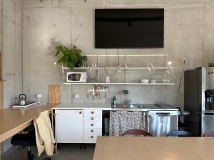 a kitchen with a sink and a tv on the wall at Ohmaria Hotell, del av Ohboy Hotell in Höllviken