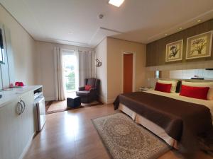 Habitación de hotel con cama y silla en Pousada Annecy - Fácil acesso ao centrinho e Baden Bar, en Campos do Jordão