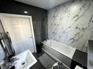 a bathroom with a white tub and a sink at Wi-Fi, 2 bathroom, 2 bedroom, sleeps 4-8 in Birmingham