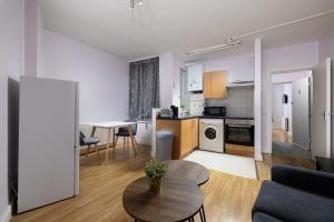 een woonkamer met een tafel en een keuken bij Charmstay Shepherds Bush in Londen