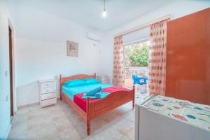 a bedroom with a bed and a desk and a window at Mirror Beach Ksamil - Vila Zervo in Sarandë