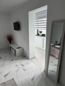 a white room with a mirror and a table at Ianis Home in Cristeşti