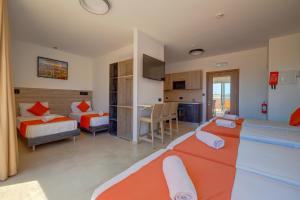 a hotel room with two beds and a kitchen at Bayside A Apartments in St. Julianʼs