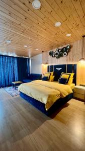 une chambre avec un grand lit et un plafond en bois dans l'établissement Clarence Cottage, à Mussoorie