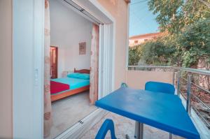a room with a balcony with a bed and a table at Mirror Beach Ksamil - Vila Zervo in Sarandë