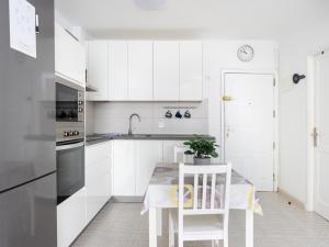 una cocina con armarios blancos y una mesa con una planta en Live Candelaria Tres Carabelas, en Candelaria