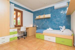 a bedroom with a bed and a desk and a chair at Finca Miralles in Búger