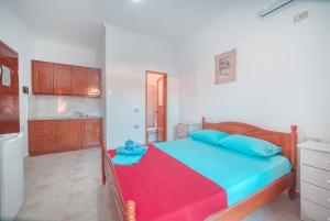a small bedroom with a bed and a kitchen at Mirror Beach Ksamil - Vila Zervo in Sarandë