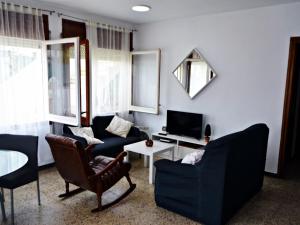 - un salon avec deux chaises et une télévision dans l'établissement AFRODITA Casa con dos apartamentos independientes, à Pineda de Mar