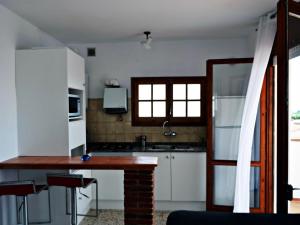 une cuisine avec des placards blancs et un comptoir dans l'établissement AFRODITA Casa con dos apartamentos independientes, à Pineda de Mar
