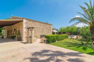 a stone house with a garden and a driveway at Finca Miralles in Búger