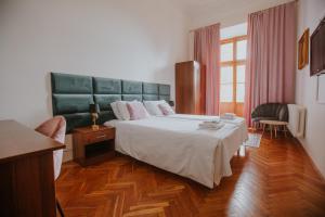 a bedroom with a large bed with a green headboard at Dwór Zbożenna in Przysucha