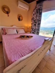 a large bed in a room with a large window at VILLA CHRYSANTHOS in Ágios Matthaíos +30 photos