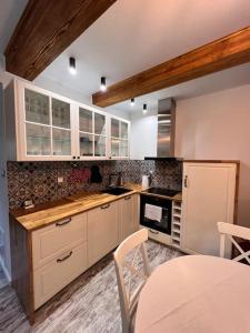a kitchen with white cabinets and a table with chairs at Siedlisko Żabickie 