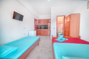 a room with two beds and a tv in it at Mirror Beach Ksamil - Vila Zervo in Sarandë