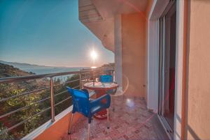 a balcony with a table and chairs and a view of the ocean at Mirror Beach Ksamil - Vila Zervo in Sarandë