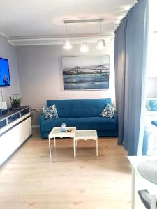 salon z niebieską kanapą i stołem w obiekcie Moje Miejsce w Gdańsku