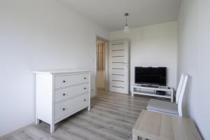 sala de estar con cómoda blanca y TV en 01 Sopot - Apartament mieszkanie dla 6 osób en Sopot