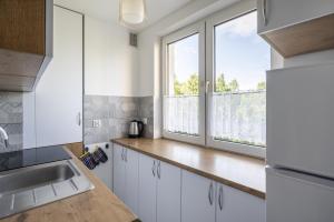 uma cozinha com armários brancos e uma janela em 01 Sopot - Apartament mieszkanie dla 6 osób em Sopot