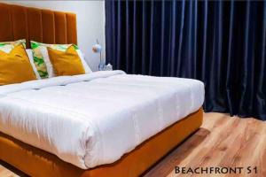 Boulevard de la corniche في الدار البيضاء: غرفة نوم بسرير ابيض كبير مع مخدات صفراء