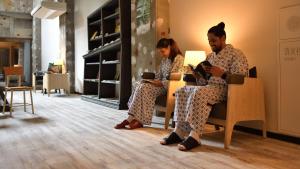 a man and a woman sitting in chairs with their phones at Shin Toji Hotel Lulud in Nakanojo +58 photos
