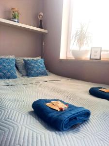 a large bed with a blue blanket on it at Moje Miejsce in Gdańsk
