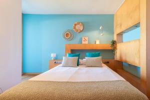 Un dormitorio con una cama grande con paredes azules. en El Balcón de Cíes, en Vigo