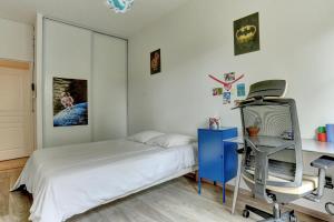 1 dormitorio con cama, escritorio y silla en L'Ulysse, en Méré