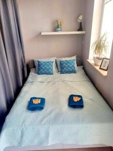 a bed with blue pillows and blue towels on it at Moje Miejsce in Gdańsk