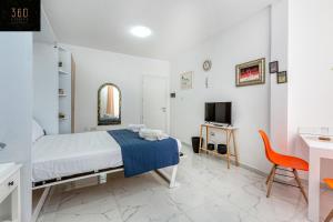 um quarto com uma cama, uma secretária e uma televisão em The Sliema Studio Stay by 360 Estates em Sliema