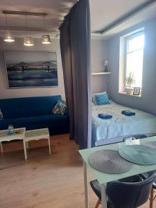 salon z niebieską kanapą i stołem w obiekcie Moje Miejsce w Gdańsku