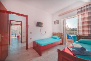 a bedroom with two beds and a balcony at Mirror Beach Ksamil - Vila Zervo in Sarandë