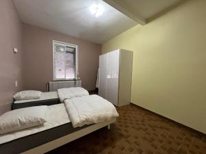 1 dormitorio con 2 camas y ventana en Gîte du Plouy, en Caumont