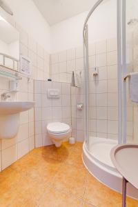 W łazience znajduje się toaleta, umywalka i prysznic. w obiekcie Pokoje Hotelowe Norbit w mieście Grodzisk Mazowiecki