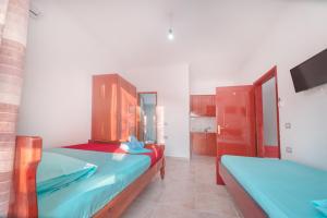 a room with two beds and a tv in it at Mirror Beach Ksamil - Vila Zervo in Sarandë