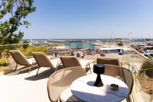 a table and chairs on a balcony with a view of a harbor at Rezident Tomis Marina in Constanţa
