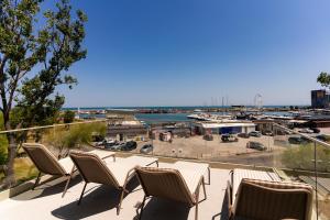 a balcony with chairs and a view of a marina at Rezident Tomis Marina in Constanţa