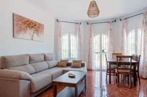 een woonkamer met een bank en een tafel bij Sunset El Tejar in Almogía