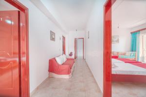 a living room with a red couch and a mirror at Mirror Beach Ksamil - Vila Zervo in Sarandë