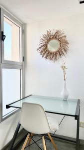 una mesa de cristal con una silla blanca y un espejo en Hollywood Suites & Lofts en Buenos Aires