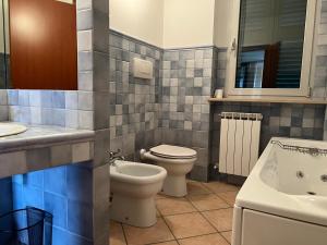 uma casa de banho com um WC, um lavatório e uma banheira em casa mimose rosa II em SantʼAngelo in Pontano