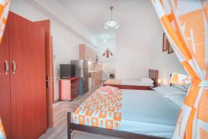 a small bedroom with two beds and a kitchen at Mirror Beach Ksamil - Vila Zervo in Sarandë