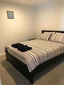 a bedroom with a bed with a black shirt on it at Governor Place-Modern Complex in Kingston 