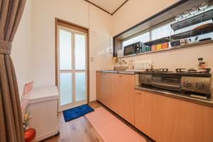 a kitchen with a stove and a window at R-house 3rd 埼玉 in Takasagochō