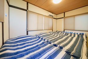 a large bed in a room with windows at R-house 3rd 埼玉 in Takasagochō