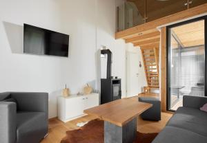 een woonkamer met een houten tafel en een televisie bij Chalet-Resort Montafon in Sankt Gallenkirch