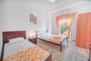 a bedroom with two beds and a window at Mirror Beach Ksamil - Vila Zervo in Sarandë