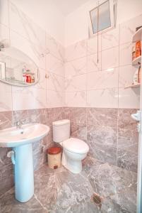 a bathroom with a toilet and a sink at Mirror Beach Ksamil - Vila Zervo in Sarandë