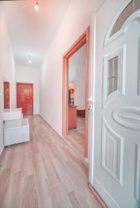 an open door into a living room with wood floors at Mirror Beach Ksamil - Vila Zervo in Sarandë